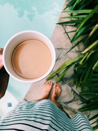 Low section of person holding coffee cup