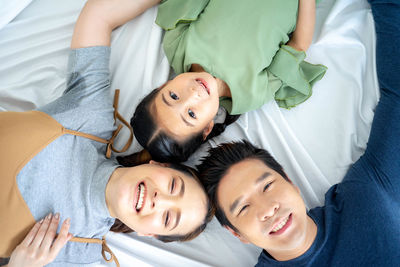 Portrait of happy woman lying on bed