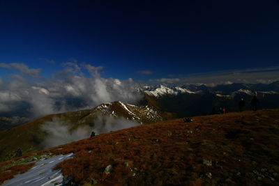 Scenic view of snowcapped mountains against blue sky