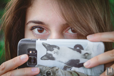 Close-up portrait of girl holding smart phone