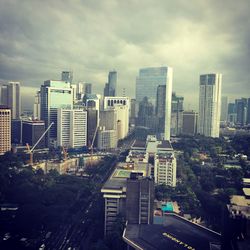 View of cityscape against cloudy sky