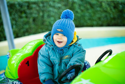 Little boy riding a car in amusement park