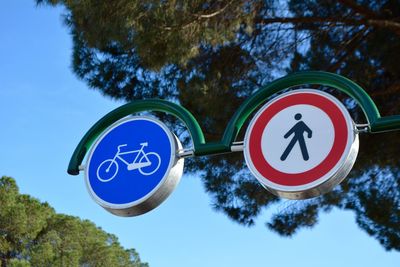 Low angle view of road sign against clear blue sky