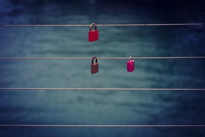 Low angle view of locks on clothesline against sky