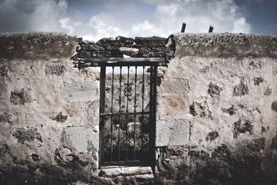 Low angle view of old building against cloudy sky