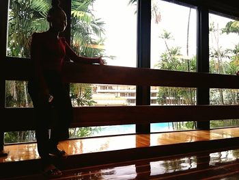 Low section of silhouette woman standing by window