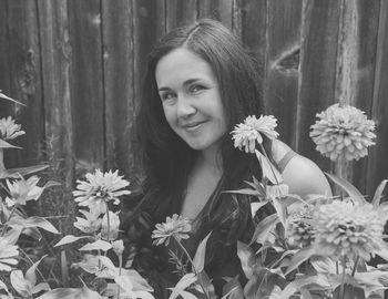 Portrait of smiling woman by flowering plants