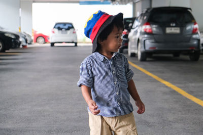 Boy standing on road in city