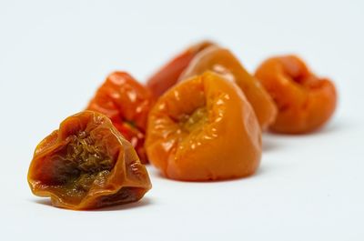 Close-up of oranges on table against white background