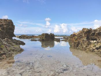 Rocks on beach against sky