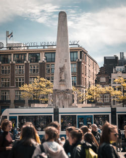 People on street against buildings in city