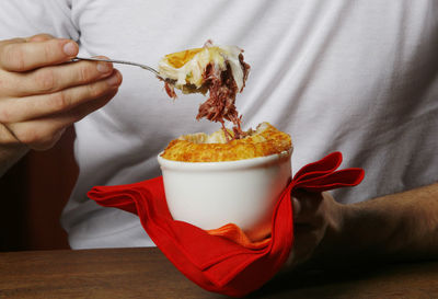 Close-up of hand holding cassava cream on table