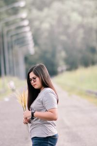 Side view of a young woman standing on road