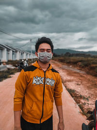 Portrait of young man standing against sky