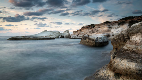 Rock formations in sea against sky