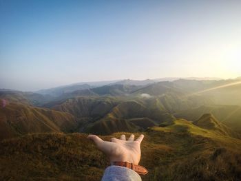 Midsection of person on mountain against sky