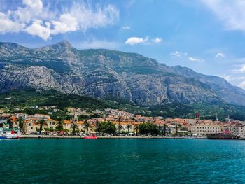 Aerial view of townscape by sea against sky