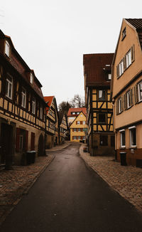 Street amidst houses against clear sky