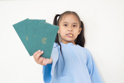 Portrait of a smiling girl standing against white background