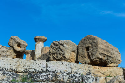 Low angle view of rock formation against clear blue sky