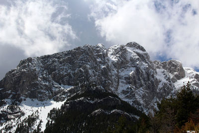 Low angle view of snowcapped mountain against sky