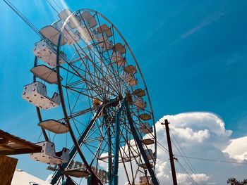 Low angle view of ferris wheel against blue sky