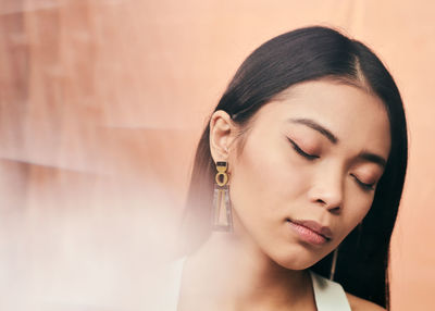 Close-up portrait of a young woman with eyes closed