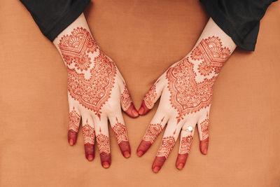 Cropped image of hands with henna tattoo