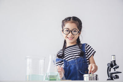 Portrait of smiling girl standing against glass