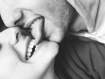 Close-up of smiling young woman biting tongue of boyfriend