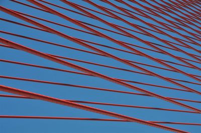 Low angle view of suspension bridge against clear blue sky