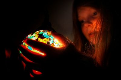 Close-up of illuminated lamp over black background