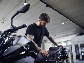 Expert checking motorcycle seat at repair shop