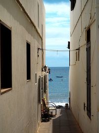 Buildings by sea against sky