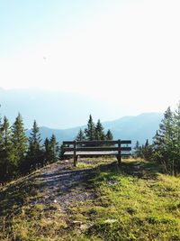 Empty bench on hill against mountain