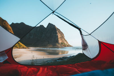 Sea seen through tent against rocky mountains