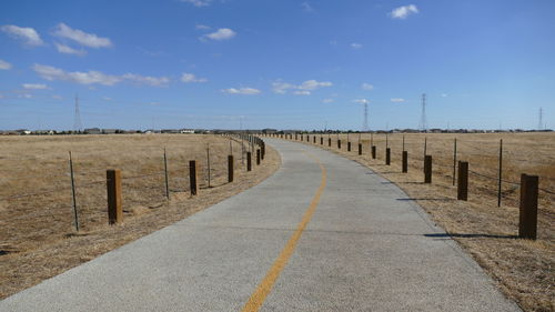 Wooden posts on road against sky