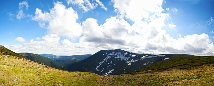 Scenic view of mountains against cloudy sky