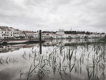 Reflection of buildings in river against sky