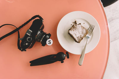 High angle view of brownie with camera and tripod on table