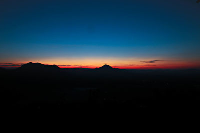 Scenic view of silhouette mountains against sky at sunset