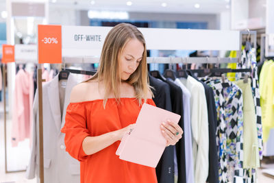 Shopping woman. happy woman with handbag enjoying shopping in red dress.