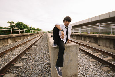 Full length of man standing on railroad track against sky