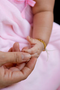 Cropped image of person holding baby girl hand