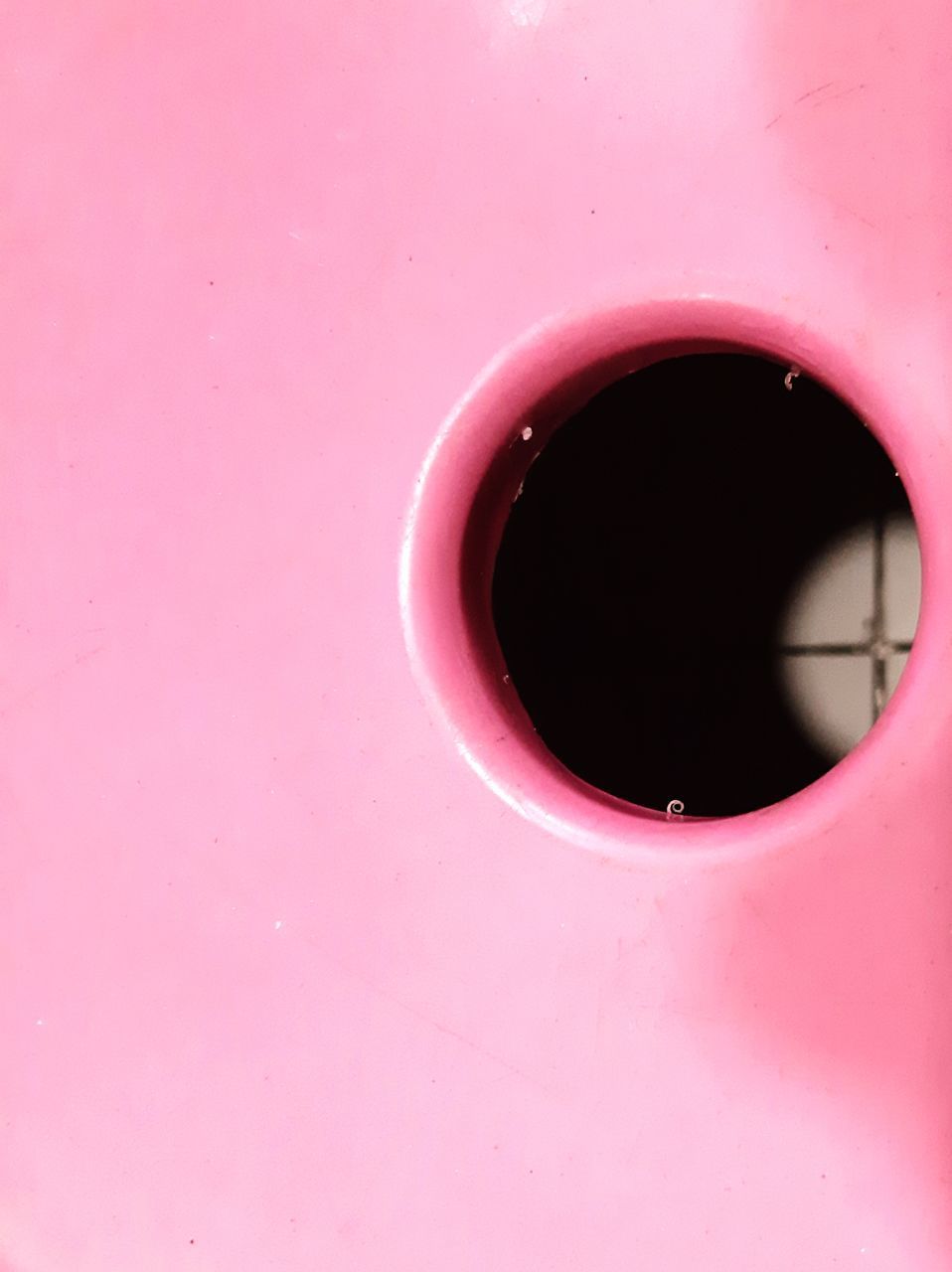 FULL FRAME SHOT OF PINK WALL WITH RED HOLE