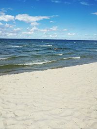 Scenic view of beach against cloudy sky