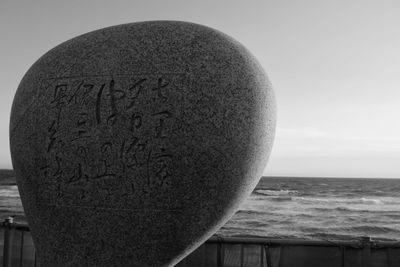 Close-up of text on beach against sky