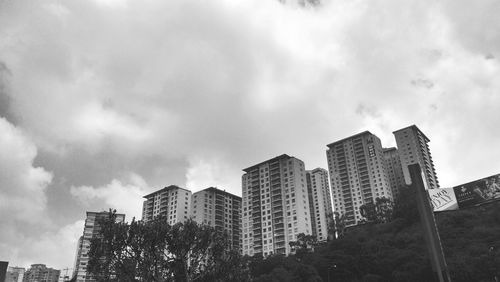 Low angle view of modern building against cloudy sky