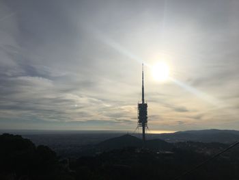 Communications tower and buildings against sky