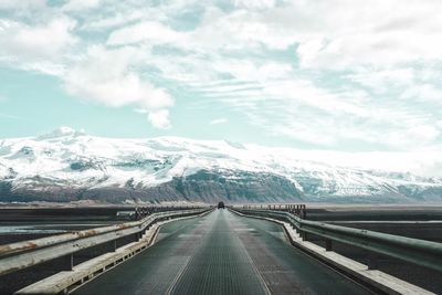 Road against snowcapped mountains and cloudy sky